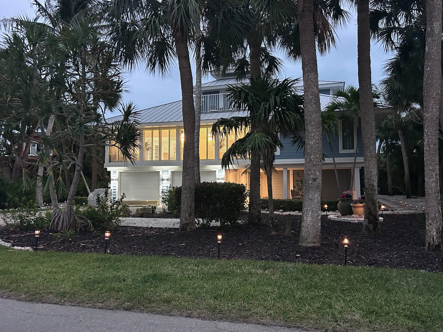 Sanibel waterfront villa surrounded by palms at dusk